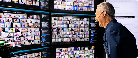 Person analyzing multiple screens with video calls